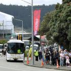Cruise ship passengers await transportation on shuttle services outside the Toitu Otago Settlers...