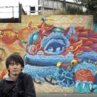 Street artist Koryu Aoshima with his near-complete work on the abutment of the King Edward St...