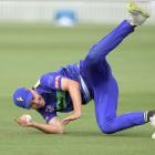 Canterbury Kings player Chad Bowes skies a ball which Travis Muller, of the Otago Volts, holds...