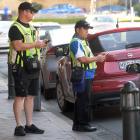 Dunedin City Council parking officers survey lower Stuart St on Monday. PHOTO: STEPHEN JAQUIERY