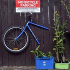 A bisected bicycle hangs as a warning outside the property of Lawrence Tamplin, who says he will...