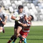 South Island Scorpions player Te Kaio Cranwell charges through the tackle of Counties-Manukau...