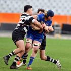 Taieri lock Brodie Hume gets stopped by Southern defenders James Simpson-Te Pairi (left) and Jack...