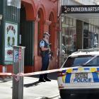 An armed officer stands guard while a scene examination takes place at Yours, a cafe and arts...