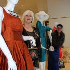 Glenda McGowan (left) and Sue Partel inspect gowns with a story at the Community Gallery in...