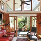 The living area has a raised ceiling and recycled sliding doors that lead into the conservatory.