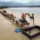 Workers construct the boardwalk over Lake Waihola as part of the Clutha Gold Trail extension from...