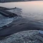 Water pours through the Kakhovka Dam in Ukraine, flooding large swaths of residential and...