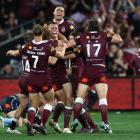 Queensland players celebrate a try to Cameron Munster against New South Wales. Photo: Getty Images