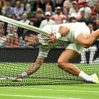 Novak Djokovic falls over the net during his fourth round match against Poland's Hubert Hurkacz....