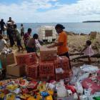 Victims of the devastating underwater eruption in Tonga in 2022 unpack goods sent shortly...
