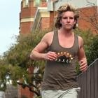 University of Otago geography student Christian Griffin trains barefoot in Castle St, for the...