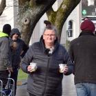 Janine Walker and her tiny "security" dog serve soup to the homeless at a caravan at the Oval...