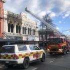 Firefighters continue working at the scene of a fire in central Invercargill yesterday. PHOTO:...