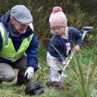 Craig Radford and his granddaughter, Olivia Hodgson,  plant a tree that Olivia has affectionately...