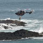 The Otago Regional Rescue Helicopter winches a surfer from Bird Island after they became caught...