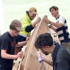 Working on a double-hulled waka are (clockwise from left)  Mikey Little, Zayvia Parata, Nick...