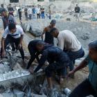 Palestinians work on clearing the destruction of a house in the aftermath of a strike amid the...