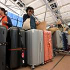 Passengers wait with their luggage at the reopened terminal of Hamburg Airport following the...