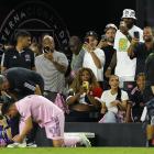 Lionel Messi  ties a shoelace while Serena Williams and LeBron James take photos and celebrity...