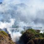 Firefighters battle to extinguish a fire threatening a house on Test St in Oamaru. The fire...