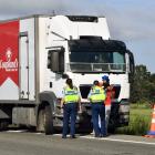 Police speak to a truck driver who was allegedly assaulted and had his truck damaged in an road...