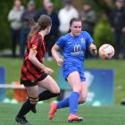 Southern United wing-back Freya Partridge-Moore taps the ball on under pressure from Ellerslie...