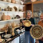 Otago Potters Group committee members Liz Rowe (left) and Bronwyn Gayle hold decorated pottery...