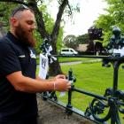 Chris Moore, of Isaac Construction, ties a white ribbon to the fence of First Church of Otago...