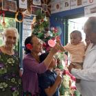 Finau Taungapeau (second from left) helps decorate the Christmas tree with (from left) her mother...