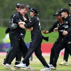Matt Rowe (left), of New Zealand, celebrates with team-mates after taking the wicket of Numan...