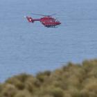 A helicopter flies over Cape Saunders about 5pm on Saturday after police received a mayday call....