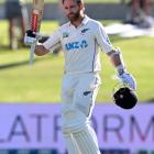Kane Williamson raises his bat after scoring a century during day one of the first test against...