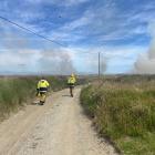 Firefighters approach the scene of the blaze that is spreading the grassy dunes at Oreti Beach....