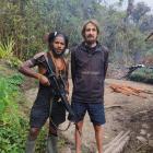 New Zealand pilot Phillip Mehrtens stands with a West Papua National Liberation Army soldier,...