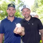 Amateur golfer Karl Tily (right), of Wellington, displays the ball  he used to score a hole-in...