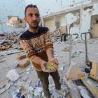 A Palestinian man at the site of an Israeli strike on an aid warehouse in Al-Nuseirat refugee...