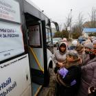 Voters gather outside a mobile polling station located in a bus, on the final day of Russia's...