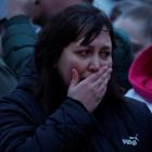 A woman reacts in front of a makeshift memorial to the victims of a shooting attack set up...
