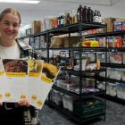 Clutha Budget Advisory Service food hub assistant Jess Michelle holds up recipe cards from their...