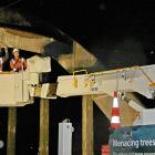 Crews work on separate hydraulic platforms during recent maintenance work on Balclutha bridge....