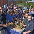 Enviroschool educator Scott Martin supplies fresh adobe bricks to Waiwera South School pupils Ivy...