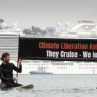 Paddleboarders James Rust (left) and Andrew Sutherland hold a protest banner up as 'Majestic...