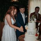 Sean and Mikayla Rowe cut their three-tier wedding cake at a reception attended by their closest...