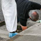 Police investigators searching for evidence down a drain on Sunderland Dr. Photo / Paul Taylor
