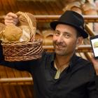 Taste Nature owner and shopkeeper Clinton Chambers holds a selection of bread he has been able to...