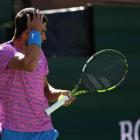 Carlos Alcaraz tries to swat away bees that interrupted his match at Indian Wells. Photo: Getty...