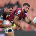 Highlanders fullback Jacob Ratumaitavuki-Kneepkens passes the ball in the tackle of Chiefs loose...