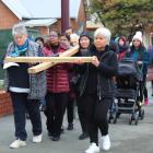 Women take over the carrying the cross during the Good Friday Cross Walk from Wachner Pl in Esk...