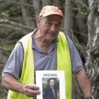 Murray Cumming, the stepfather of Jon Ellison, holds a missing persons poster in Bethunes Gully...